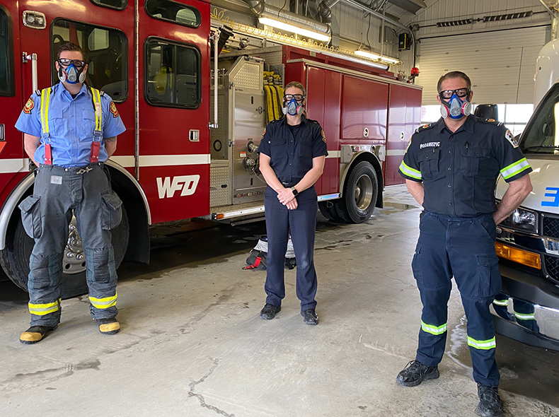 WFPS employees with COVID masks standing in front of emergency vehicles 