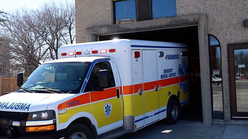 A Winnipeg Fire Paramedic Service ambulance pulls out of a garage.