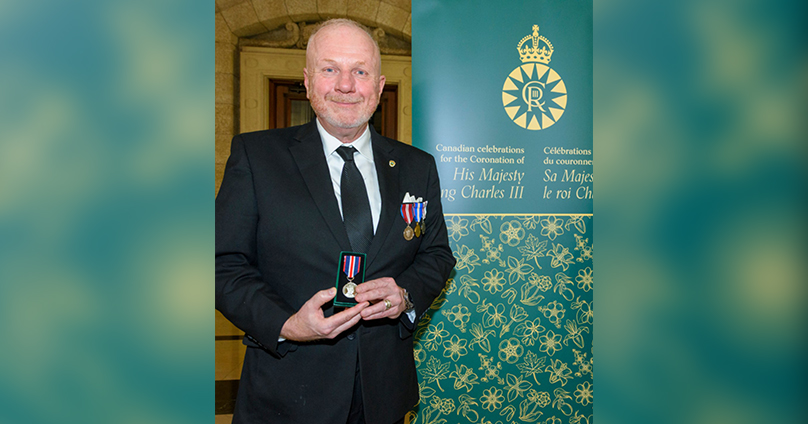 Kenny Boyce holding his King Charles Medal
