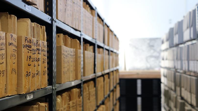 City archives, stored in folders and boxes, sitting on shelves.