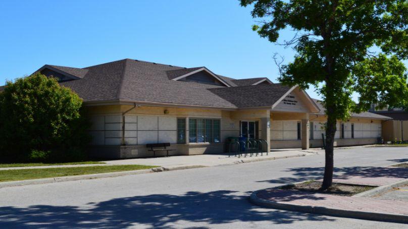 Entrance to the Sir william stephenson library showing parking lot and trees