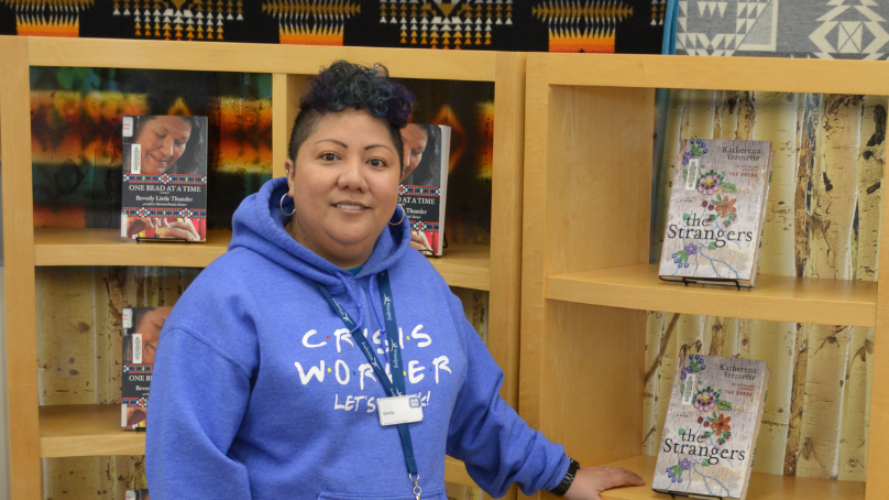 Individual standing in front of a book shelf