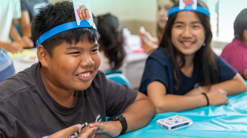 two kids playing headband game and smiling