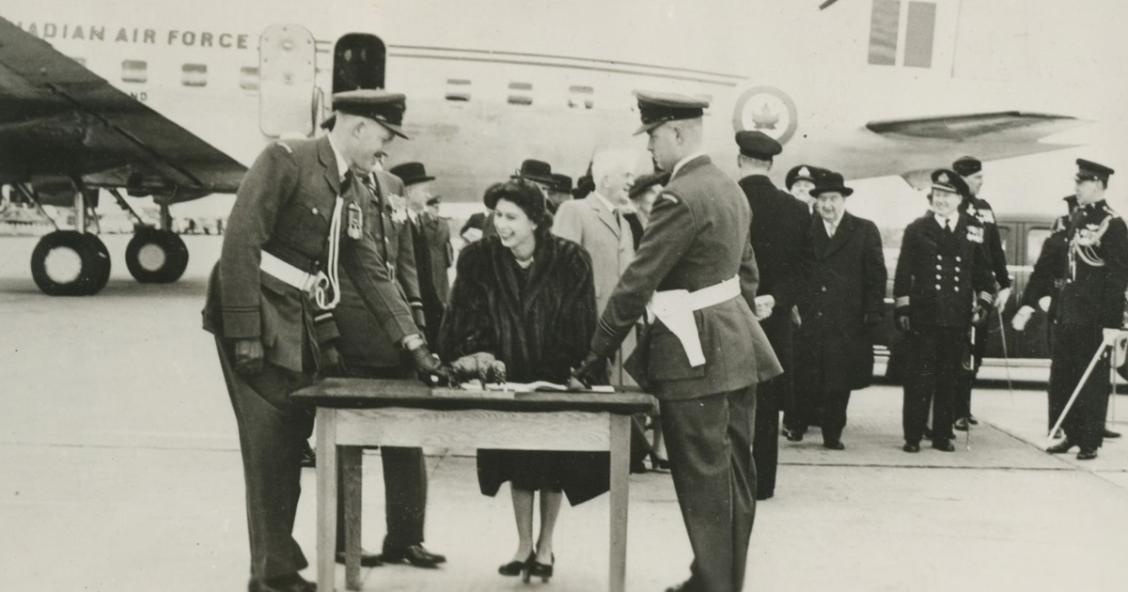 Royal Tour, Winnipeg, October 16, 1951. Princess Elizabeth, Duchess of Edinburgh (later Queen Elizabeth II) smiles as she signs a document during her Royal Tour with the Duke of Edinburgh (or Prince Philip). City of Winnipeg Archives.