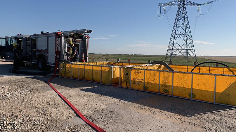 Portable tanks are set up at a fire scene to hold the water in areas without fire hydrants.