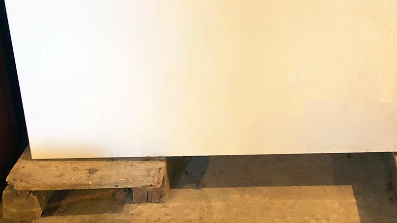 A chest freezer raised on pieces of wood.