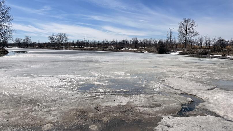 Ice melting on a retention pond in spring.