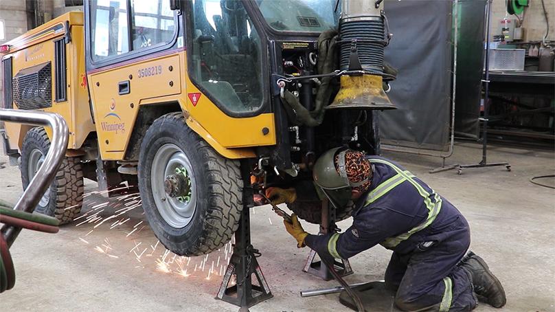 An employee works on repairing a City vehicle.
