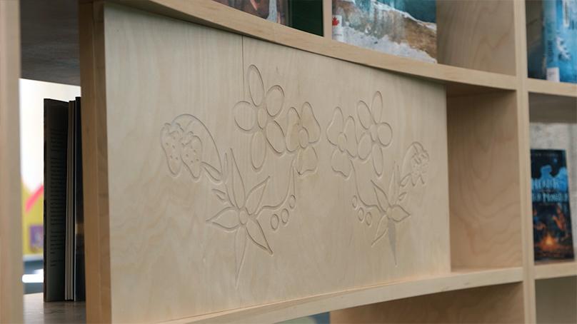 Wild strawberry plants and flowers carved into bookshelves in the space.