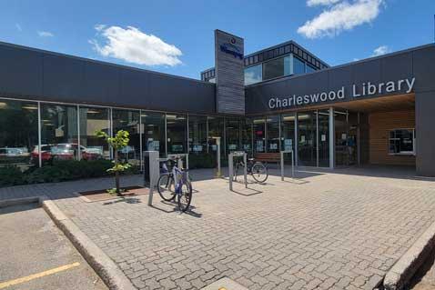 Entrance to Charleswood Library branch showing blue sky and bikes parked outside