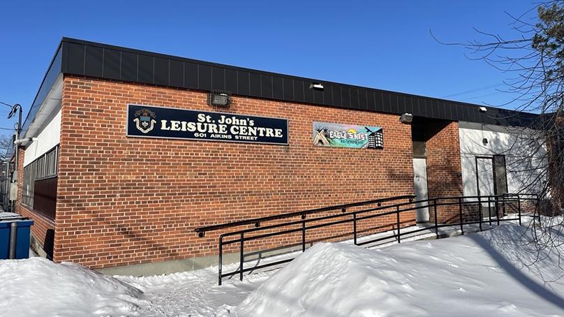 A sloped ramp with railings leads to the St. John’s Leisure Centre’s entrance on a winter’s day.