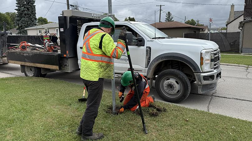 Neighbourhood Action Team members straighten a sign.