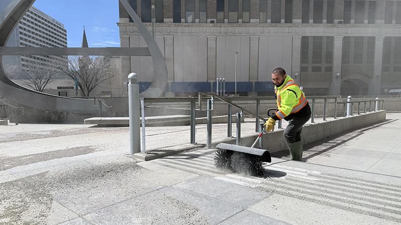 The Neighbourhood Action Team sweeps Millennium Library Park during the Downtown beautification blitz.