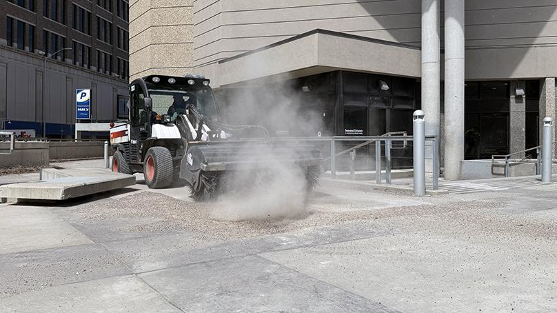 The Neighbourhood Action Team sweeps Millennium Library Park during the Downtown beautification blitz.